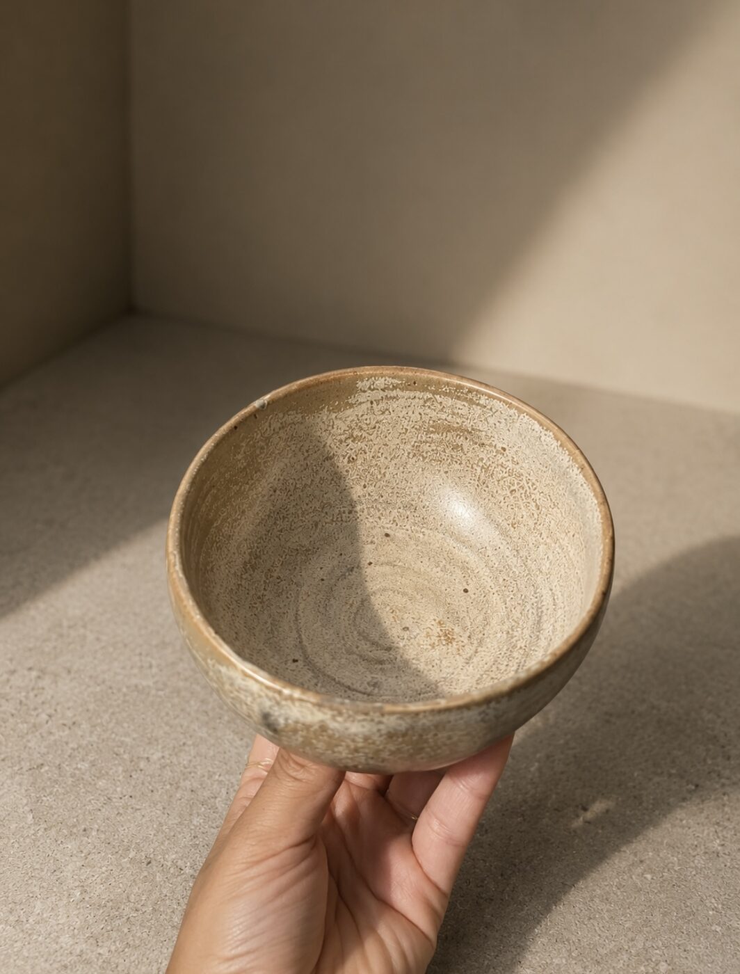 Speckled stoneware bowl held in hand
